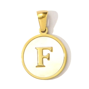 Macro detail of round golden pendant with white shell inlay and 3D letter F engraving
