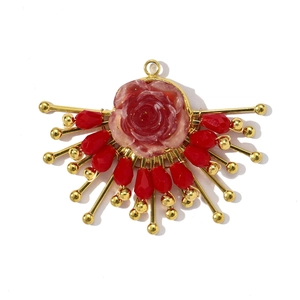 Détail du pendentif fleur en cristal rouge avec pétales métalliques dorés rayonnants