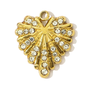 Détail d'un pendentif cœur doré avec des crêtes radiales et des strass brillants