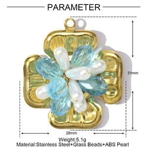 Detailed view of cross flower pendant with blue glass beads and pearl on stainless steel