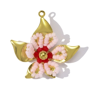 Detailed close-up of a handmade floral pendant with gold metal and pink crystal beads