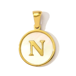 Macro detail of gold-plated circular shell pendant with 3D embossed letter N detail