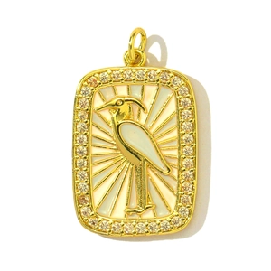 Détail d'un pendentif doré avec oiseau en émail blanc et pierres de zircone étincelantes