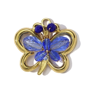 Macro shot of gold butterfly pendant with blue faceted crystal inlay and clear diamond accent