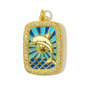 Détail du pendentif dauphin en or avec motif de vagues en émail bleu et bordure en zircon