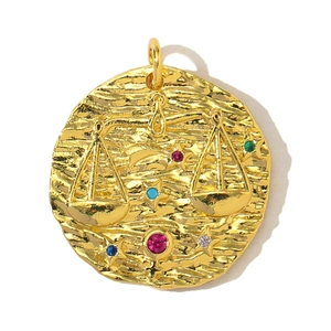 Detailed macro view of a gold Libra zodiac pendant with colorful zircon stones