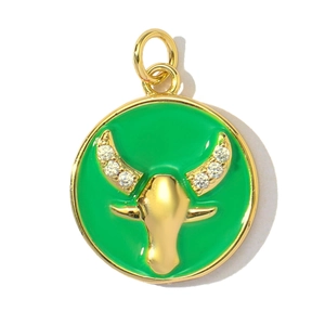 Macro detail of Taurus zodiac charm with gold ox head and green enamel inlay