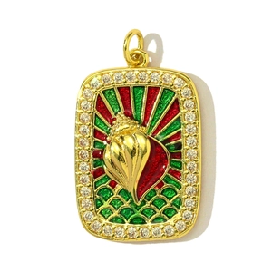 Détail d'un pendentif doré avec émail rouge-vert, motif coquillage et bordure en zircone