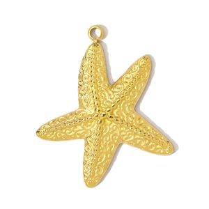 Détail d'un pendentif étoile de mer doré avec des volutes complexes et une texture perlée
