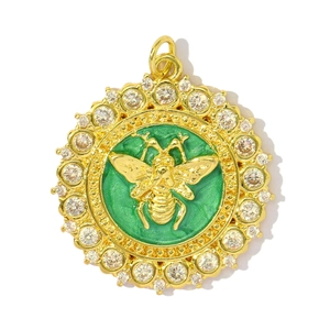 Macro detail of a round green enamel pendant with golden bee relief and crystal halo