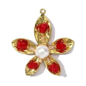 Detailopname van gouden bloemhanger met rode kristallen en centrale parel