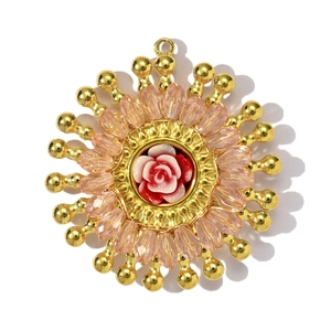Détail d'un pendentif fleur fait main avec perles de cristal roses et cœur de rose en résine