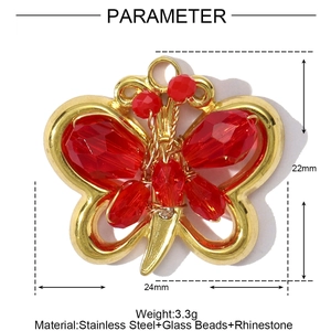 Detailed view of a gold stainless steel butterfly pendant with red crystal beads and rhinestones