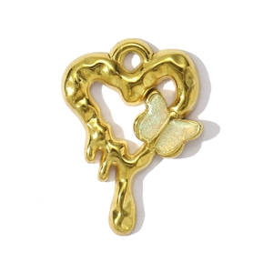Close-up of golden melting heart pendant with sparkling butterfly on white background