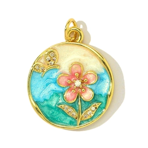 Détail macro du pendentif fleur et papillon en émail avec cristaux sur base dorée