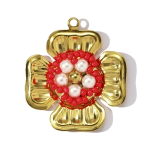 Détail macro du pendentif fleur française aux pétales dorés et centre perlé