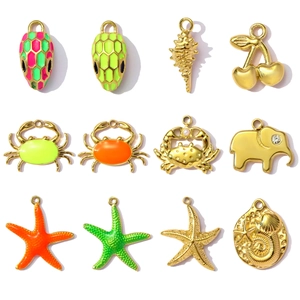 Detailopname van geëmailleerde zeester en krab hangers in goudkleur met strassteentjes