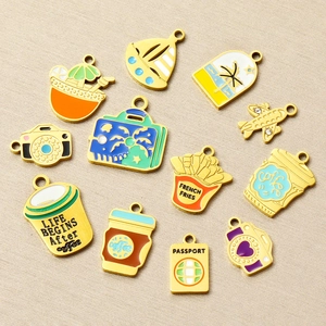 Macro shot of 12 gold stainless steel travel and food enamel pendants for DIY necklaces