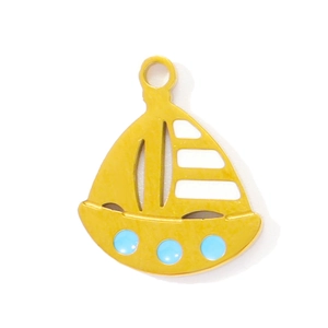 Detailed view of a gold sailboat pendant with blue dots and white enamel for DIY jewelry