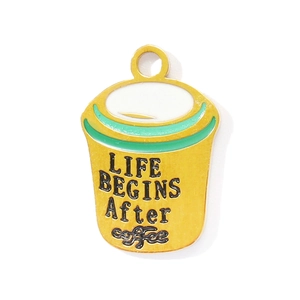 Macro shot of coffee cup enamel pendant with LIFE BEGINS AFTER Coffee engraved text