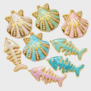 Detailed macro view of colorful enamel seashell and fishbone charms with white pearls