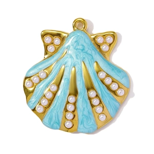 Close-up of shell pendant with blue enamel, gold plating and white pearls