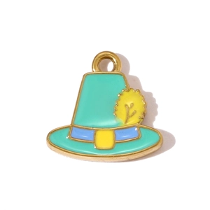 Detalle de dije de sombrero de esmalte verde con cinta azul y anillo de metal dorado