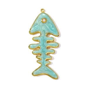 Detailed macro view of a gold-plated fishbone pendant with mint green resin and pearl eye