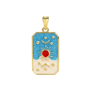 Detalle de un colgante rectangular dorado con motivos de sol, luna y estrellas en esmalte