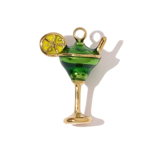Detalle de un colgante de copa de cóctel dorado con esmalte verde y rodaja de limón