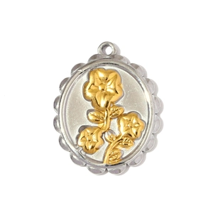 Detailed macro view of two-tone stainless steel round pendant with gold flower relief