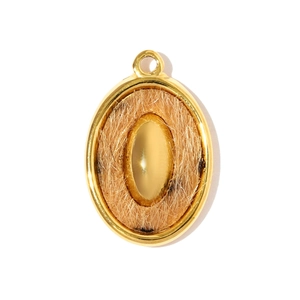 Détail d'un pendentif ovale à motif léopard avec bordures métalliques dorées