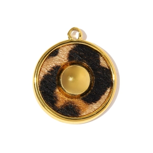 Détail macro du pendentif rond imprimé léopard avec cadre en métal doré brillant