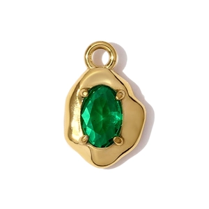 Detail of gold lava textured pendant with a four-prong set oval green gemstone