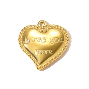Detail of a gold heart pendant with Love you more engraving and beaded edge