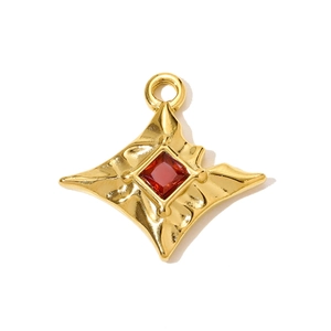 Macro d'un pendentif étoile à quatre branches plaqué or avec zircon rouge et métal ondulé