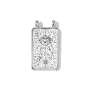 Detail of silver rectangular evil eye pendant with embossed sunburst and hammered texture