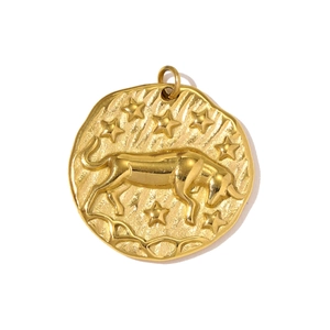 Macro view of gold stainless steel Taurus zodiac pendant with embossed bull and stars