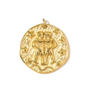 Close-up of gold Gemini zodiac embossed pendant with coin texture and star details