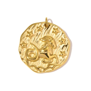 Close-up of golden zodiac Capricorn pendant with embossed goat design and star details