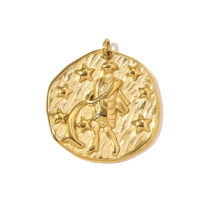 Macro shot of gold-plated Aquarius zodiac pendant with embossed figures and starry details
