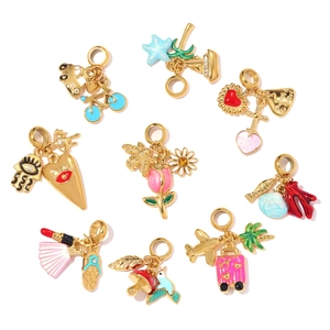 Various enamel charms in gold finish featuring colorful travel and nature motifs