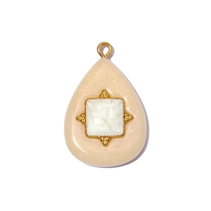 Detailed close-up of water drop resin pendant with golden frame and square inlay
