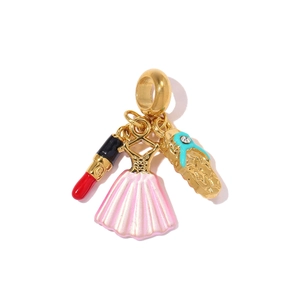 Detail of gold charms featuring a red lipstick, pink dress, and high heel shoe with rhinestones