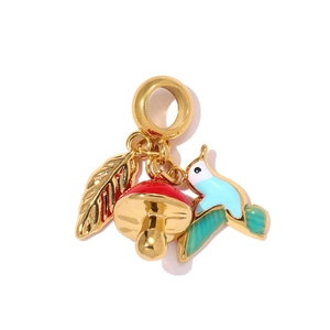 Detailed close-up of a leaf, mushroom, and bird charms on a golden lobster clasp