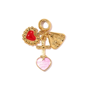Detail of gold pendant featuring red enamel heart, cross, and engraved pink heart charm