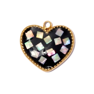 Detalle de colgante de corazón con incrustaciones de nácar y borde dorado perlado