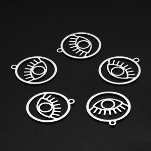 Macro shot of five stainless steel evil eye charms on a dark textured background