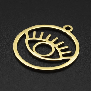 Macro view of a gold-plated evil eye circular pendant with cutout eyelash details