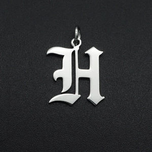 Macro-opname van gotische letter H hanger van gepolijst roestvrij staal voor kettingen